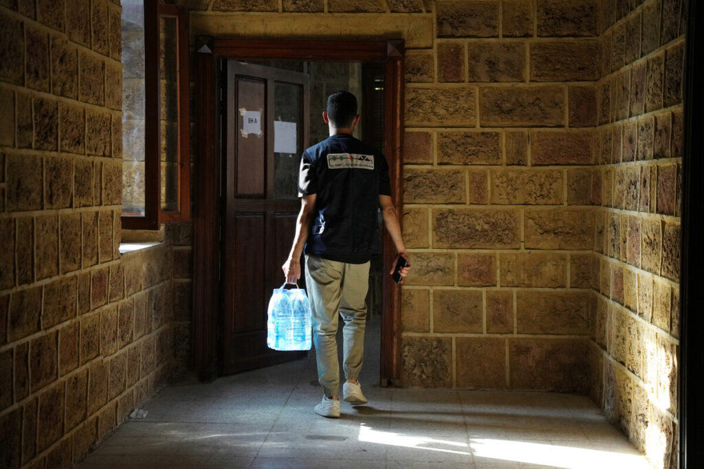 man carries water bottles